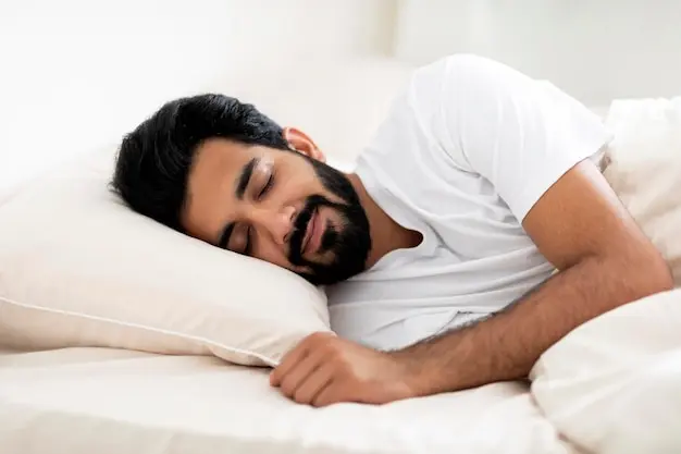 Smiling young indian man sleeping calmly in comfortable bed at home | Premium Photo
